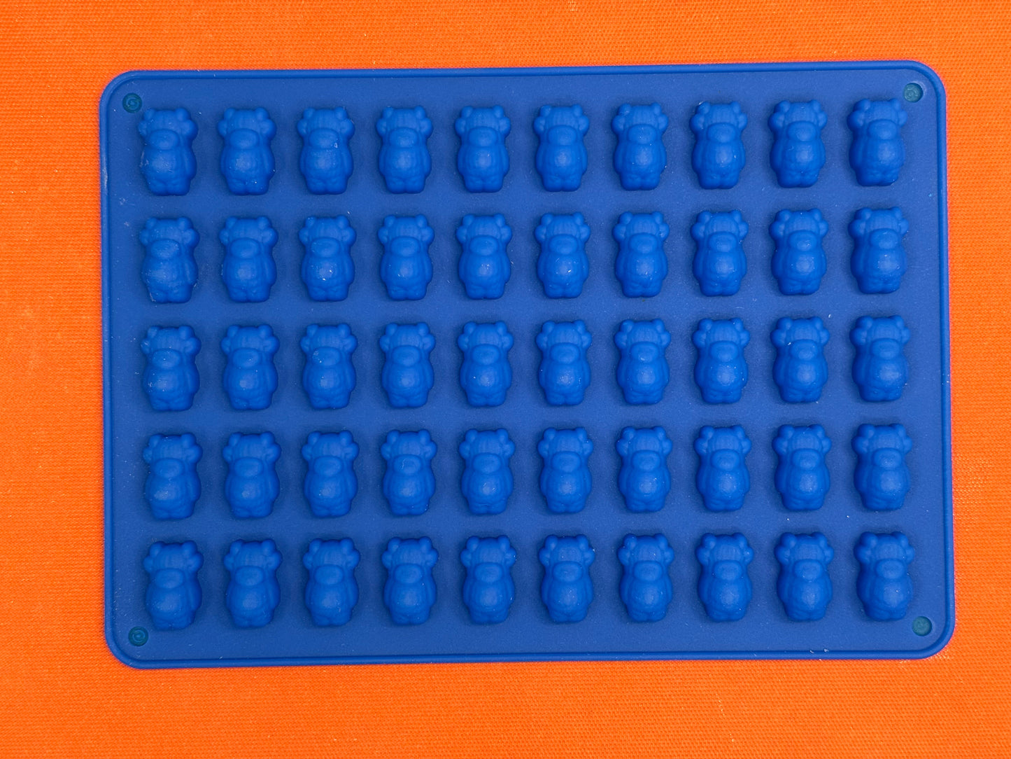 Blue silicone mold with cow shapes on an orange background