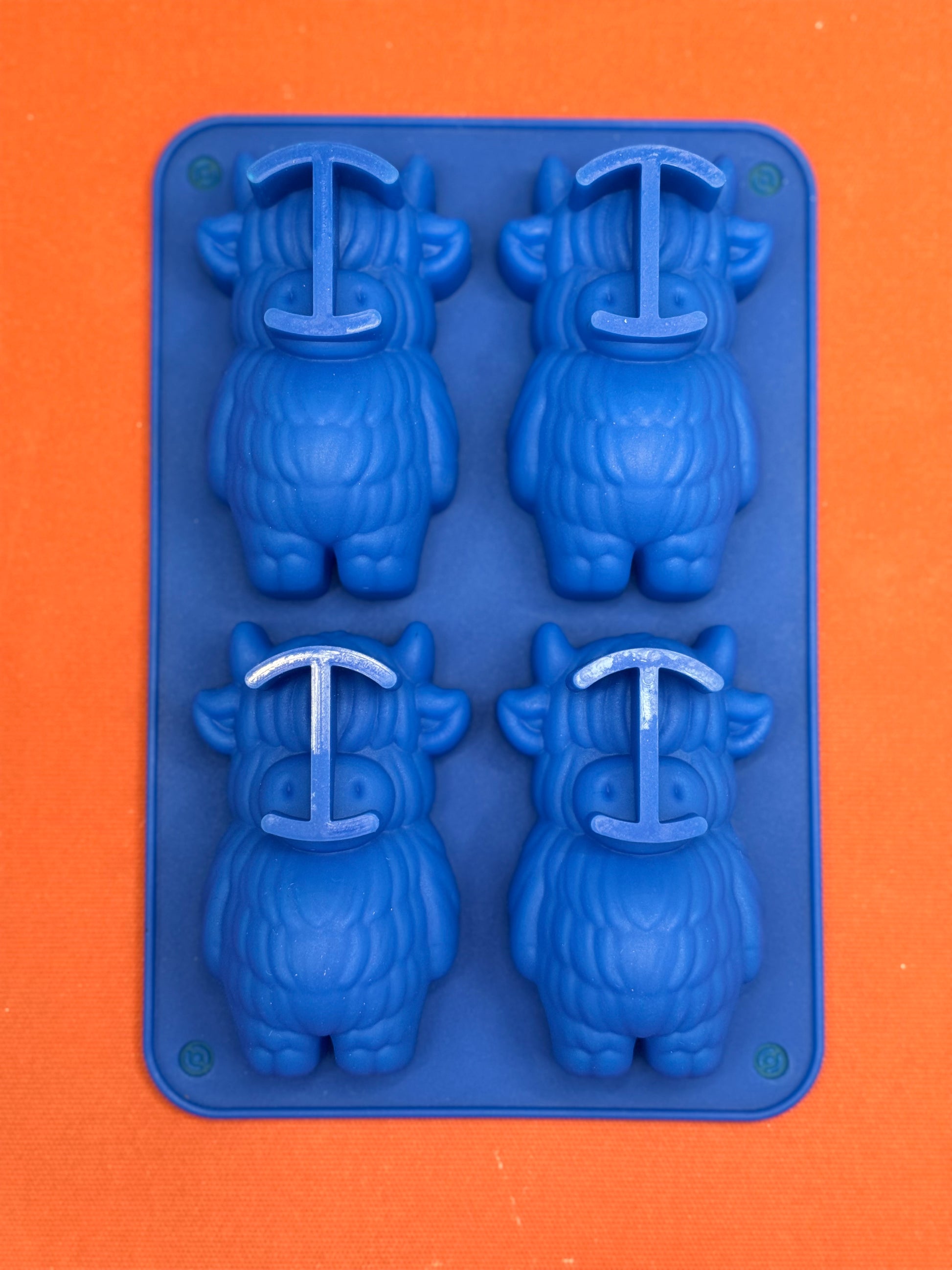 Blue silicone mold with cow shapes on  an orange background