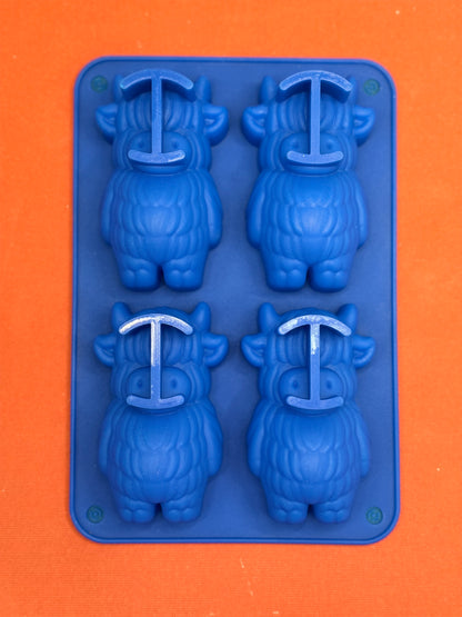 Blue silicone mold with cow shapes on  an orange background