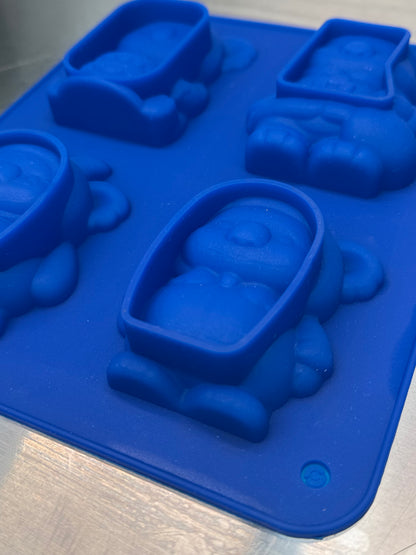 Blue silicone mold with koala character shapes on a metallic surface