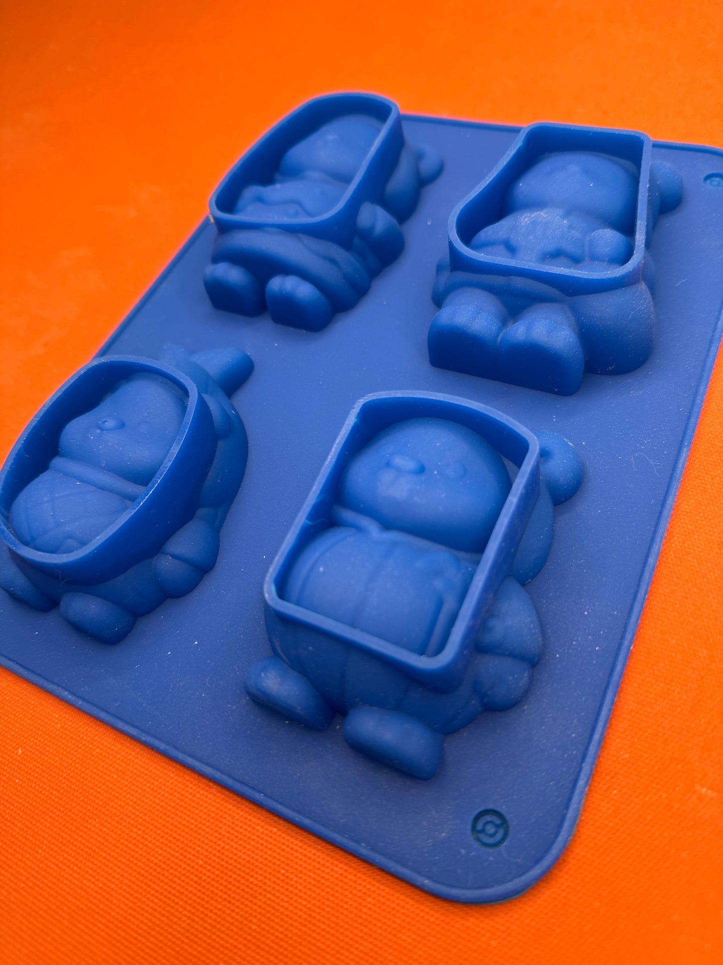 Blue silicone mold with various shapes on an orange background