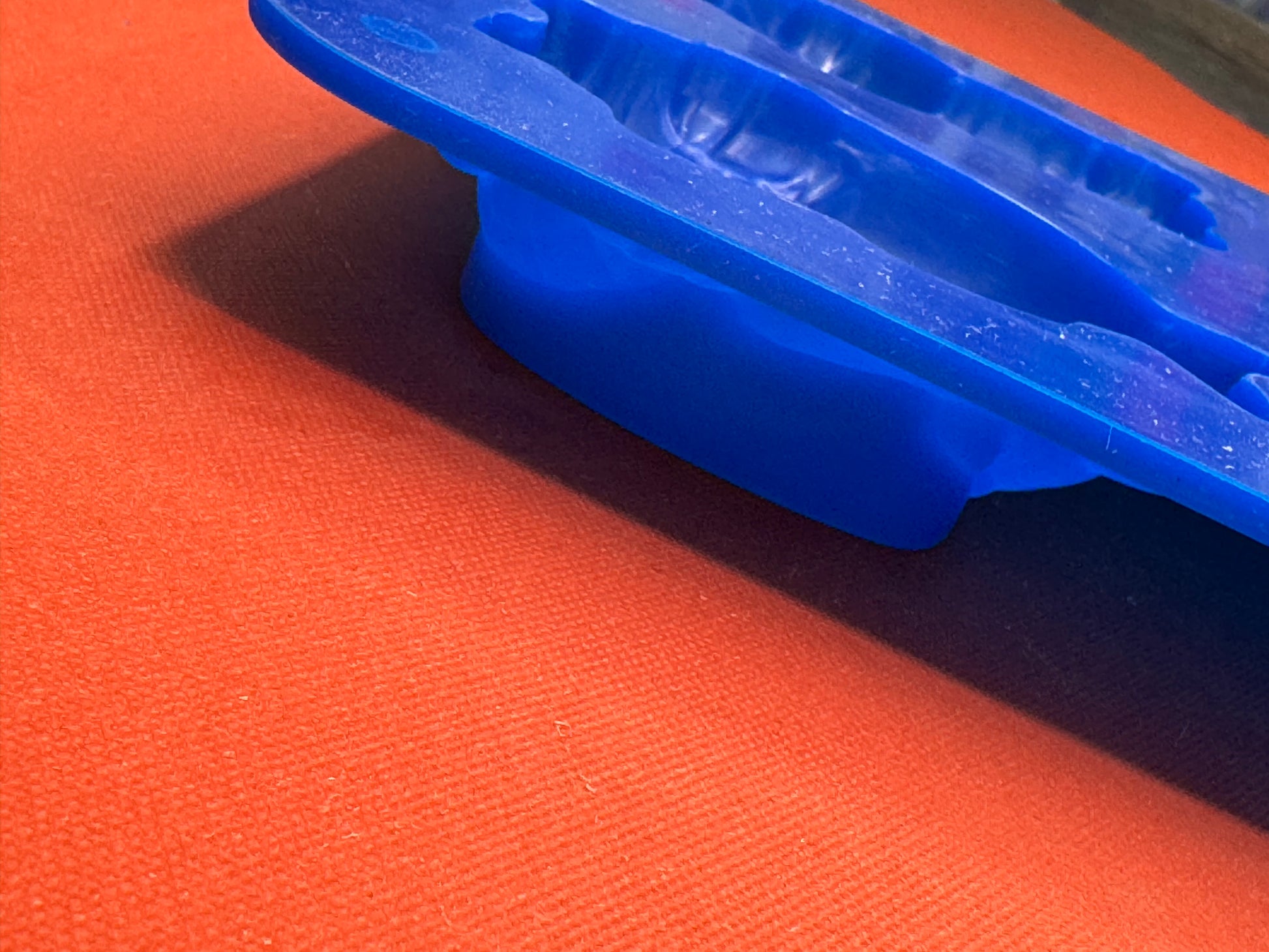 Blue plastic clip on an orange fabric background